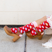 Person wearing red socks with red candy hearts and witty Christian puns