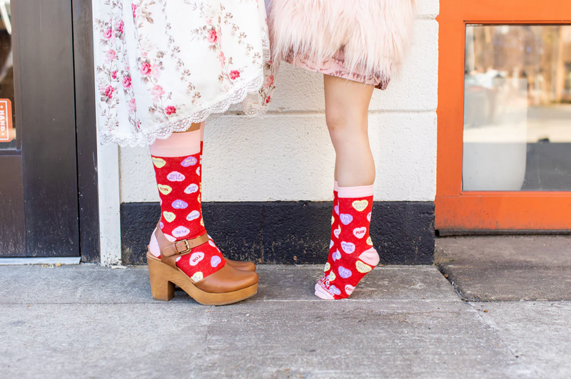 A mother and daughter wearing red socks with red candy hearts and witty Christian puns