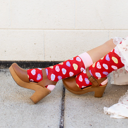 Person wearing red socks with red candy hearts and witty Christian puns