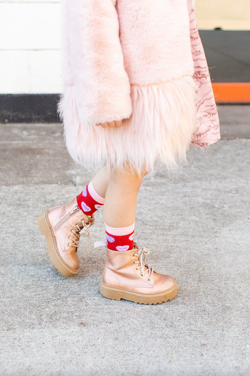Child wearing red socks with candy hearts featuring witty Christian sayings