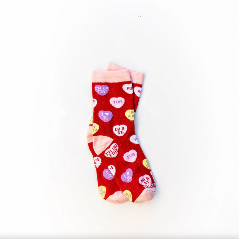 Red socks with candy hearts featuring witty Christian sayings