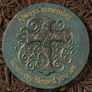Decorative stone with decorative letter 'A' and engraved text on a brown mulch background