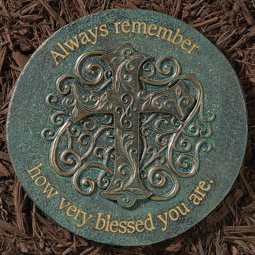 Decorative stone with decorative letter 'A' and engraved text on a brown mulch background