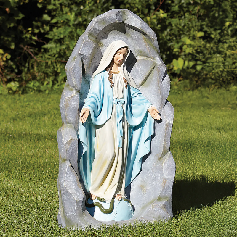 Statue of Our Lady of Grace in a natural setting with greenery