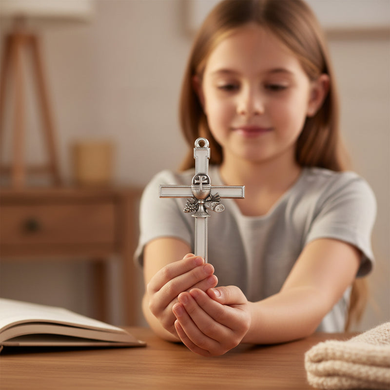 Young girl hold a white enameled First Communion gift cross with a chalice emblem.