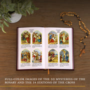 Open book with illustrations of Rosary mysteries and Stations of the Cross on a wooden surface with a rosary and plant.
