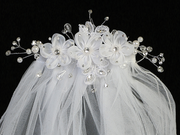 Extreme close-up on the floral details of a little girl's white sheer First Communion veil