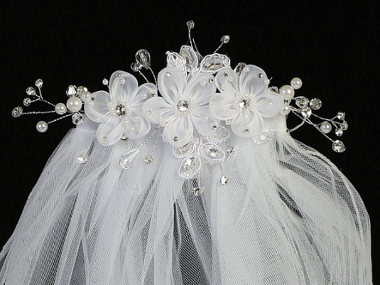 Extreme close-up on the floral details of a little girl's white sheer First Communion veil