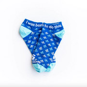 A pair of blue and white St. Joan of Arc socks with a quote printed on the ankle area that says 'I was born to do this'.