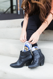 A person in white socks with blue accents and an image of Mother Teresa