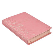 A pink faux leather Bible won a white background.