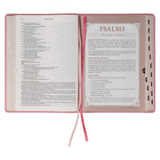 A pink faux leather Bible won a white background.