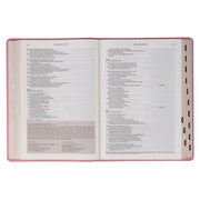 A pink faux leather Bible won a white background.