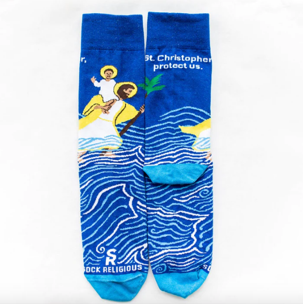 A pair of blue socks with a graphic design featuring St. Christopher and the Christ child in a nautical setting