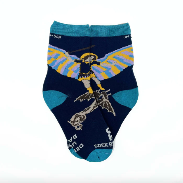 Colorful socks with images of St. Michael the Archangel worn by a child on a light background