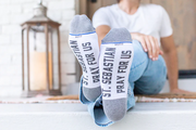 White St. Sebastian socks worn with light blue jeans on a light gray background