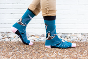Person wearing blue socks featuring an image of St. Teresa of Avilia and the Holy Spirit