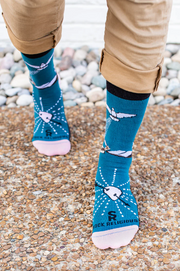 Person wearing blue socks featuring an image of St. Teresa of Avilia and the Holy Spirit