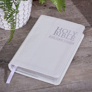 White King James Version Bible with silver text on a wood surface.