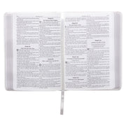 A white faux leather compact Bible open on psalms 96-101.