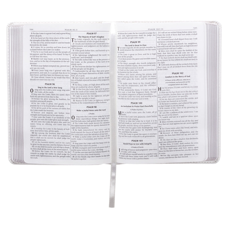 A white faux leather compact Bible open on psalms 96-101.
