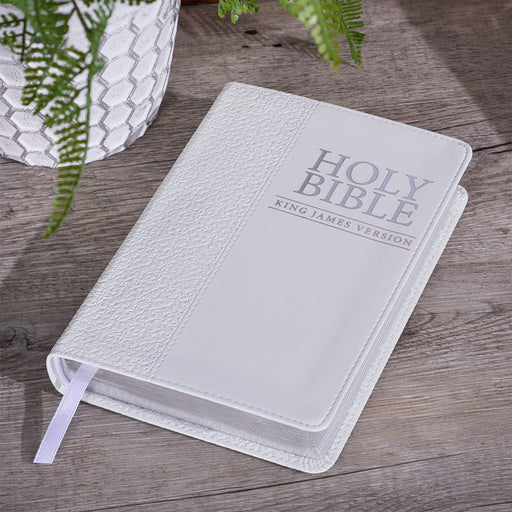 White King James Version Bible with silver text on a wood surface.