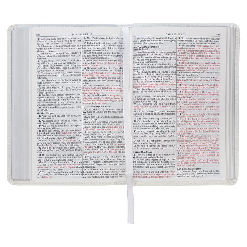 A white faux leather compact Bible with red letter text.
