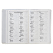 A white faux leather compact Bible with an index.