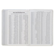 A white faux leather compact Bible with a one-year reading plan text.
