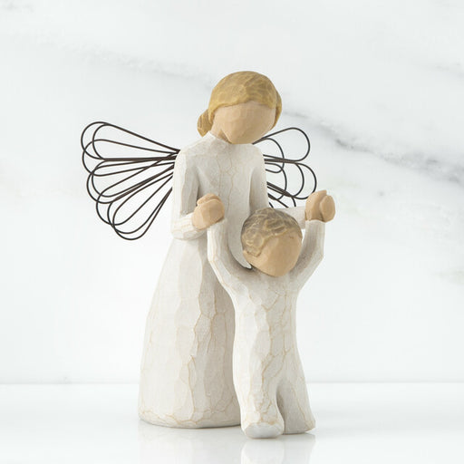A figurine of a guardian angel, with a resin and metal construction, depicted in a praying posture alongside a child.
