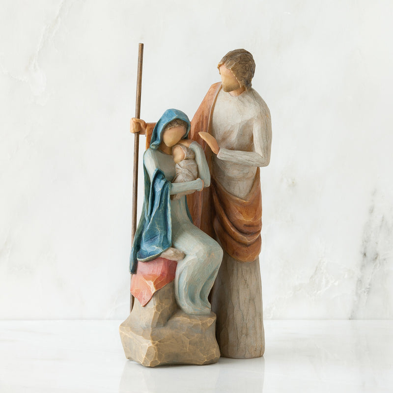 A modern, faceless, sculpted nativity figurine on a marble background